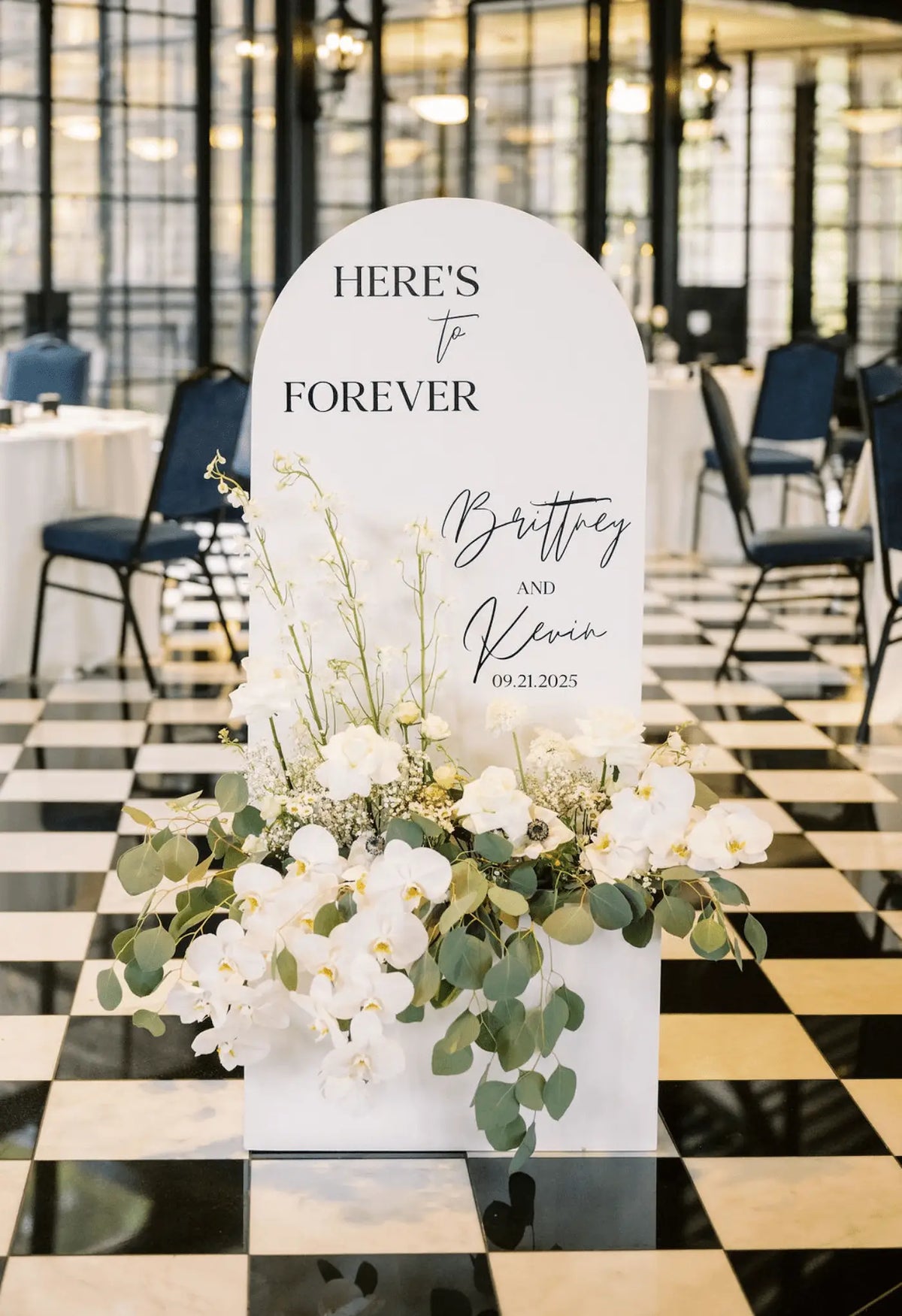 Minimalist wedding welcome sign with white florals and airy greenery arrangement