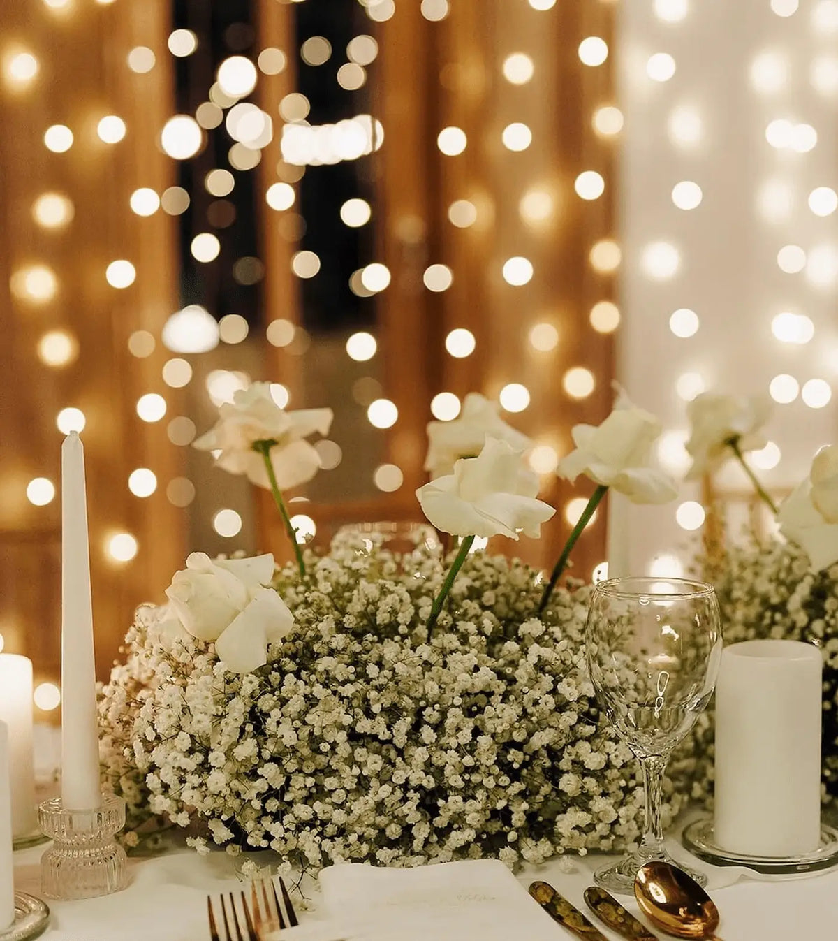 Romantic wedding table setting with candlelight and delicate white floral accents
