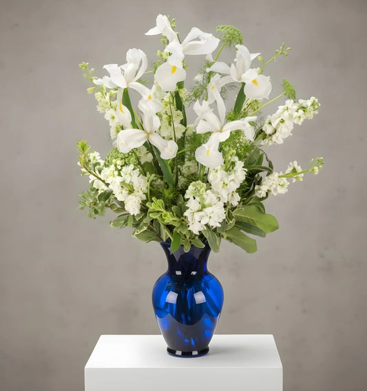 Bouquet of white flowers in a blue vase on a gray background