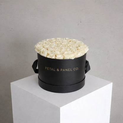 Black round box with white flowers on a gray background